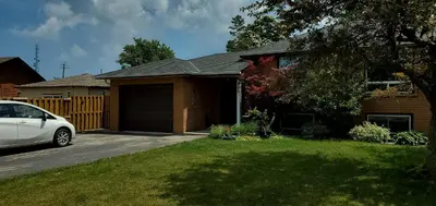 a house with a car parked in the driveway at Spacious Guest Suite in Hamilton