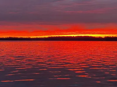 a sunset over a large body of water at Gilford Beach Apartment in Innisfil