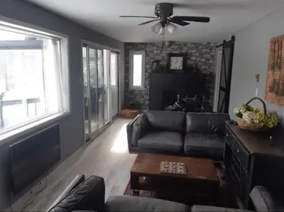 a living room with a couch and a ceiling fan at Burnt River Bungalow in Kinmount