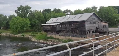 an old building sitting on the side of a river at Burnt River Bungalow in Kinmount