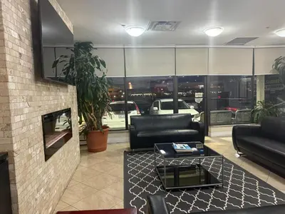 a living room with black leather couches and a table at NU Hotel Toronto Airport in Mississauga