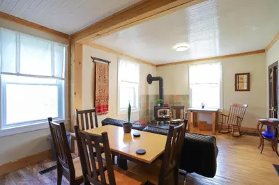 a dining room with a table and chairs and windows at 23Maple in Haliburton