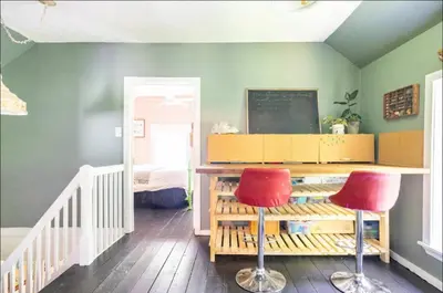 a classroom with two red chairs and a chalkboard at The River Farmhouse in Corbyville