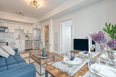 a living room with a blue couch and a table at 2 Bedroom, 2 Bath Stunning Condo - heart of Kitchener Downtown in Kitchener