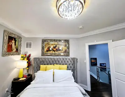 a bedroom with a large bed and a chandelier at Lilen's Home in Toronto