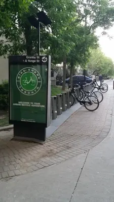 a sign on a sidewalk next to some bikes at Margie Townhome Suites in Toronto