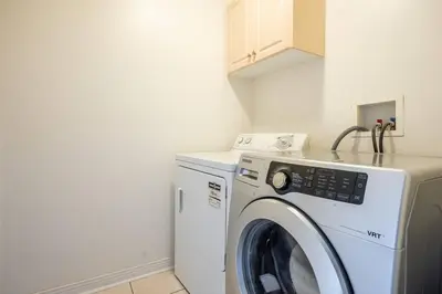 a white washer and dryer in a small room at Beautiful Townhouse In Toronto in Toronto