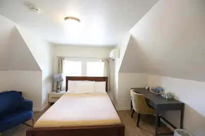 a bedroom with a bed and a desk and a window at Phoebe Wang in Toronto