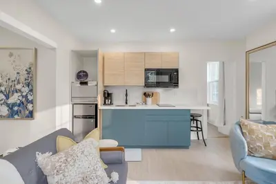 a living room with a couch and a kitchen at Beautiful Lakeside Haven in Port Hope