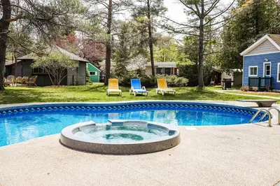 a swimming pool with two chairs in a yard at The Dockhouse Cottage Five in Wasaga Beach
