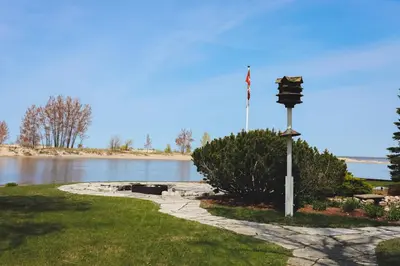 a pole with an american flag on it next to a lake at The Lighthouse Cottage Four in Wasaga Beach