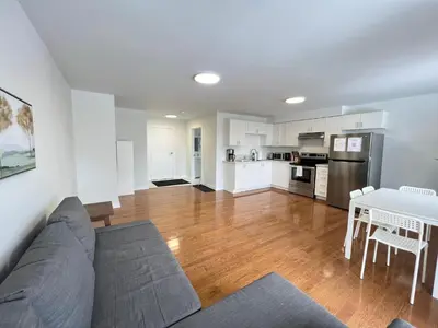 a living room with a couch and a table and a kitchen at Letitia Heights !A Spacious and Quiet Private Bedroom with Shared Bathroom in Barrie