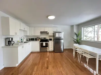 a kitchen with white cabinets and a table with chairs at Letitia Heights !A Spacious and Quiet Private Bedroom with Shared Bathroom in Barrie