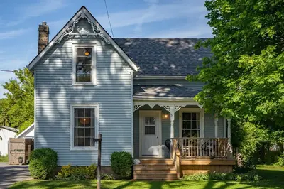 a blue house with a porch and a deck at Town & Trail - Walkable Wellington Charmer in Wellington