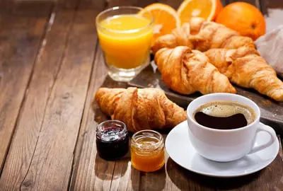 a table with a cup of coffee and croissants and orange juice at Great Canadian Casino Resort Toronto in Toronto