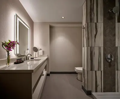 a bathroom with a sink and a toilet and a mirror at Great Canadian Casino Resort Toronto in Toronto