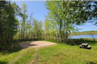 a park with a picnic table and a bench at Lovely waterfront private cottage with hot tub in Kawartha Lakes in Head Lake