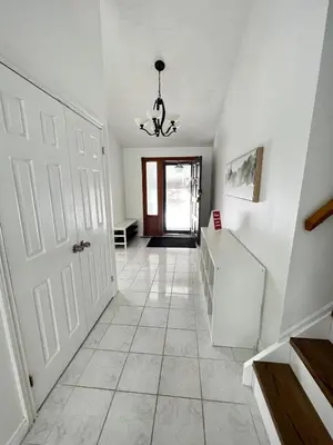 a hallway with a white door and a chandelier at Letitia Heights !G Stylish and Spacious Private Bedroom with Shared Bathroom in Barrie