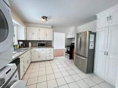 a kitchen with white cabinets and a stainless steel refrigerator at Letitia Heights !G Stylish and Spacious Private Bedroom with Shared Bathroom in Barrie