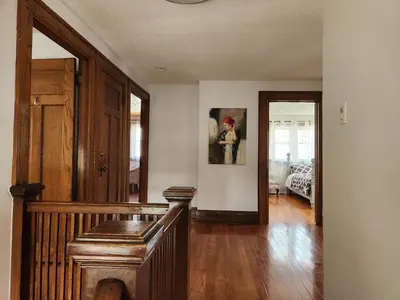 a living room with a staircase and a room with a bed at Classic Home in Niagara Falls