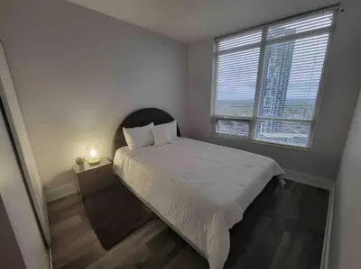 a small bedroom with a bed and a window at City Centre Lodge ( Downtown) in Mississauga