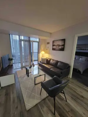 a living room with a couch and a chair at City Centre Lodge ( Downtown) in Mississauga