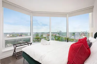 a bedroom with a large window and a bed with red pillows at Luxury 3-Beds Apartment in Yorkville with the Best City View in Downtown Toronto in Toronto