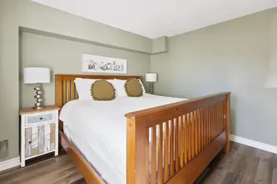 a bedroom with a wooden bed with two pillows at 3BR Bright Mountain View Condo at Blue on Monterra in Blue Mountains