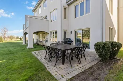 a patio with a table and chairs in front of a house at 3BR Bright Mountain View Condo at Blue on Monterra in Blue Mountains