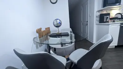 a dining room with a glass table and chairs at Konia Suites in Orangeville