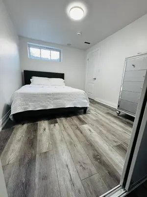 a bedroom with a bed and a wooden floor at Konia Suites in Orangeville