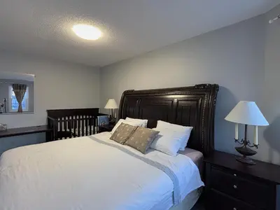 a bedroom with a large bed with white sheets and pillows at Lake Simcoe 4 Bedroom Family Home Ideal Toronto Area Retreat in Innisfil