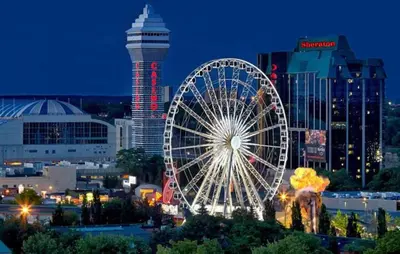 a large ferris wheel in a city at night at Two bedrooms unit with jacuzzi and great view in Niagara Falls