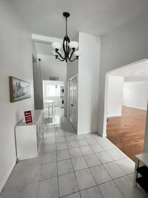 a living room with white walls and a chandelier at Letitia Heights !D Quiet and Stylish Private Bedroom with Shared Bathroom in Barrie