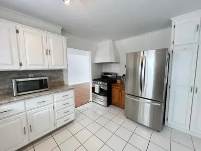 a kitchen with white cabinets and a stainless steel refrigerator at Letitia Heights !D Quiet and Stylish Private Bedroom with Shared Bathroom in Barrie