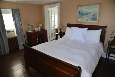 a bedroom with a large bed with white sheets at Stevenson Farms-Harvest Spa B & B in Alliston