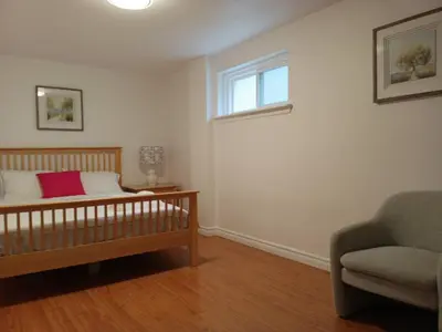 a bedroom with a crib and a chair and a window at spacious and bright house in Toronto
