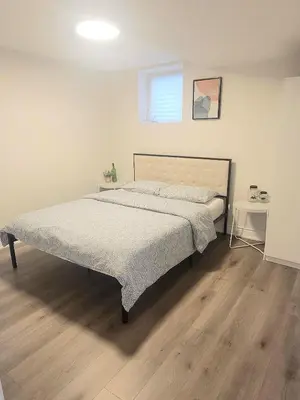 a large bed in a bedroom with a wooden floor at Lake-Walk House 3 Bed 2 Bath Apt in Hamilton