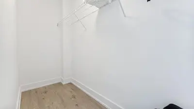 a room with a white wall and a fan at Entire Luxury Suite 4Mins To Falls, Free Parking in Niagara Falls
