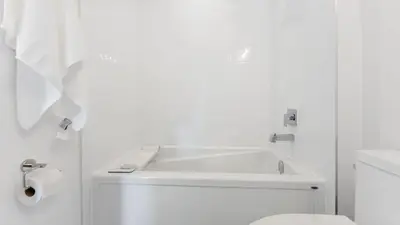 a white bathroom with a sink and a toilet at Entire Luxury Suite 4Mins To Falls, Free Parking in Niagara Falls