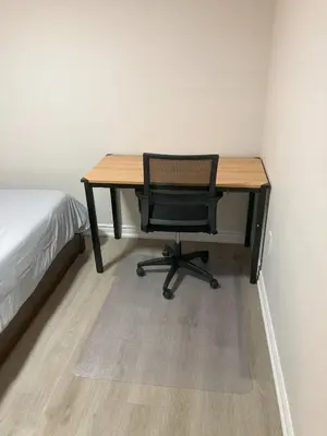 a desk with a chair in a room with a bed at Brand New, cozy 2 Bdrm Bsmnt Apt in Mississauga