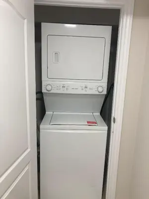 a washer and dryer in a small refrigerator at Brand New, cozy 2 Bdrm Bsmnt Apt in Mississauga