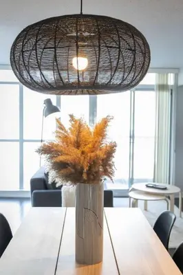 a dining room table with a vase with flowers in it at Work From home with Parking WIFI and CN Tower View in Toronto