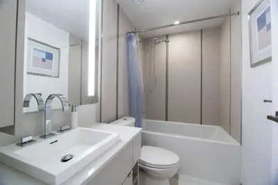 a white bathroom with a sink and a toilet and a tub at Cozy 1 BR Air mattress CN Tower Ent District MTCC in Toronto