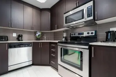 a kitchen with stainless steel appliances and a microwave at Modern Condo 1 BD 1BA with a Sofabed Downtown in Toronto