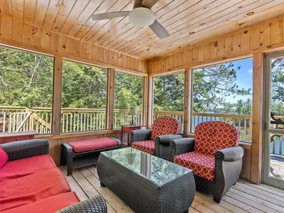 a screened in porch with chairs and a table at Getaway Cottage LAKE FRONT Muskoka Room Kayaks in Dwight