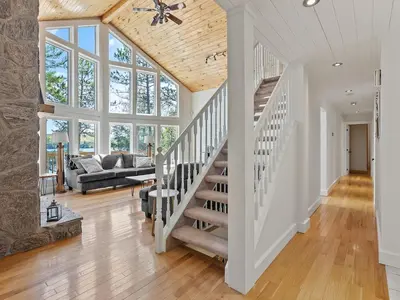 a staircase in a living room with a vaulted ceiling at Getaway Cottage LAKE FRONT Muskoka Room Kayaks in Dwight