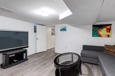 a living room with a couch and a flat screen tv at 3BR Casa close to Woodbine Beach with deck area and WFH in Toronto