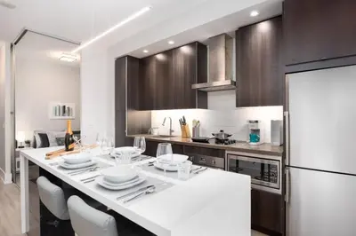 a kitchen with a white counter and a refrigerator at Luxury CN Tower View King Bed Balcony FREE PARK in Toronto