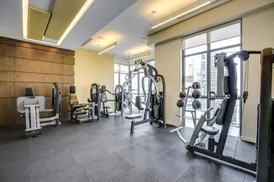 a gym with treadmills and machines in a room at Luxury CN Tower View King Bed Balcony FREE PARK in Toronto